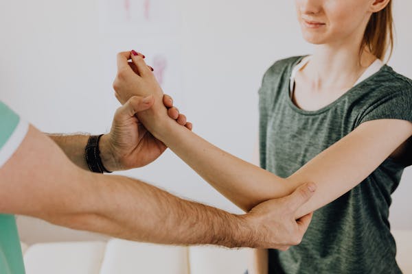 Chiropractor gently working on a patient's wrist and arm