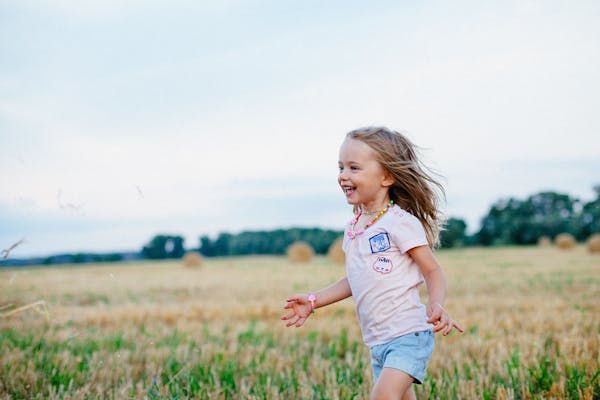 Happy child running freely through a sunlit field