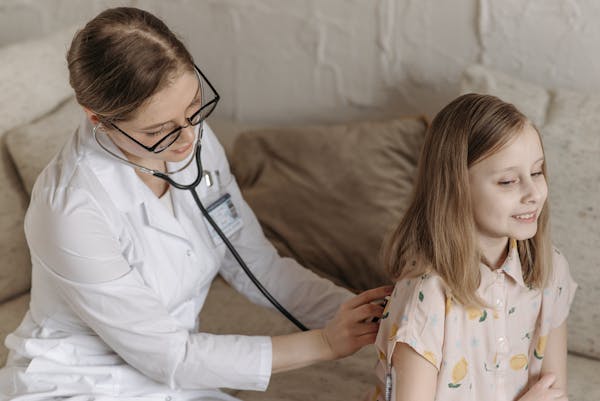 Healthcare practitioner gently examining a smiling child